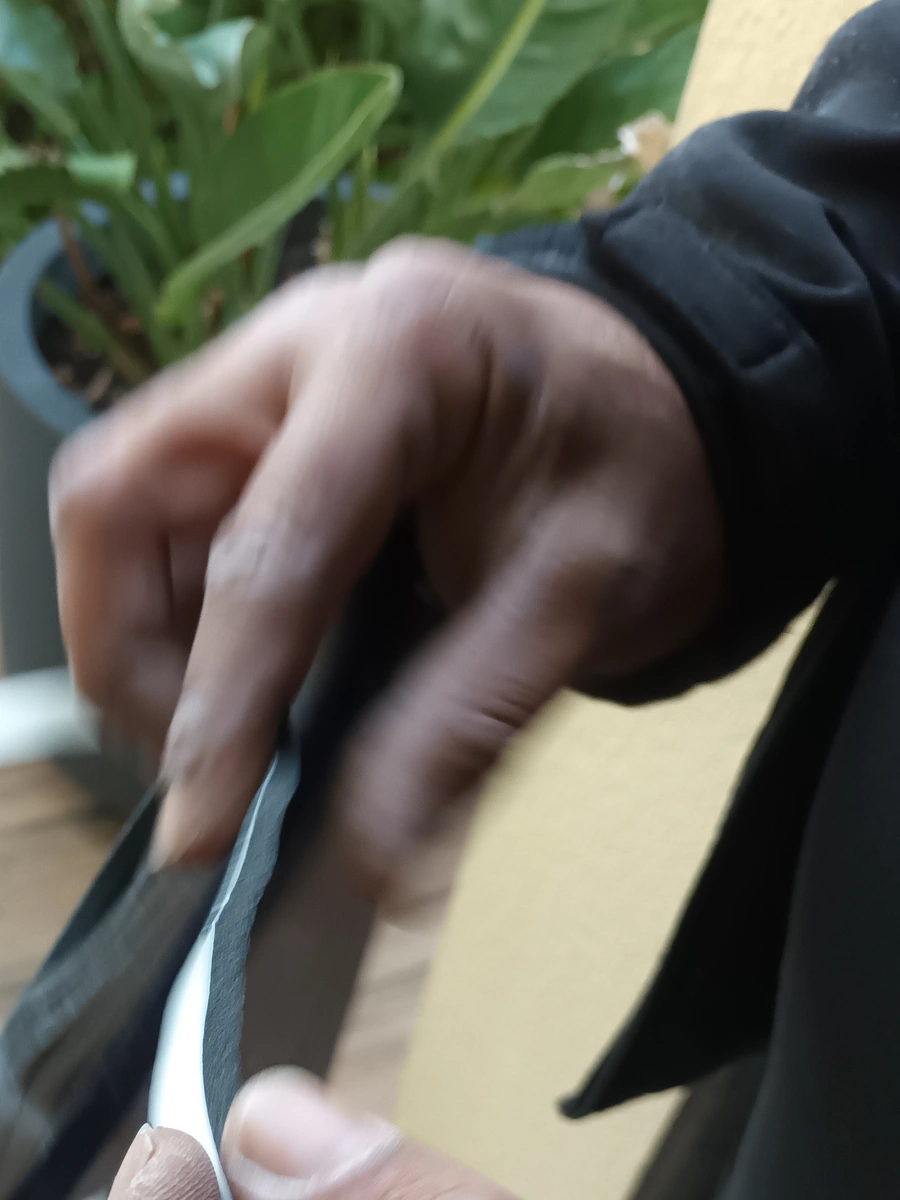 Pose du compribande d'étanchéité sur une porte de service par un menuisier Maison Aubin en Ille-et-Vilaine