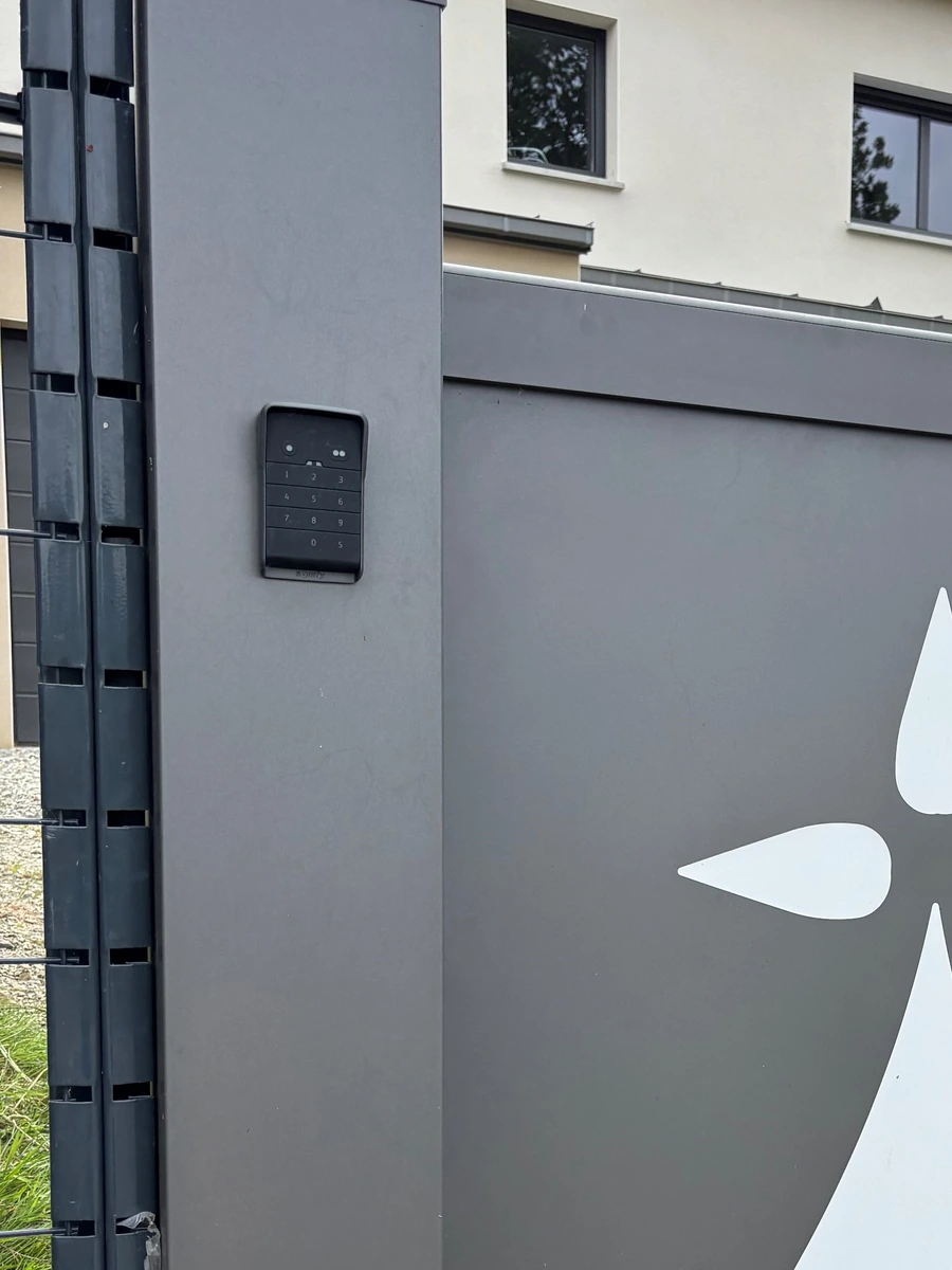 Digicode Somfy rétroéclairé sur poteau de portail aluminium gris, posé par Maison Aubin à La Selle-en-Luitre 