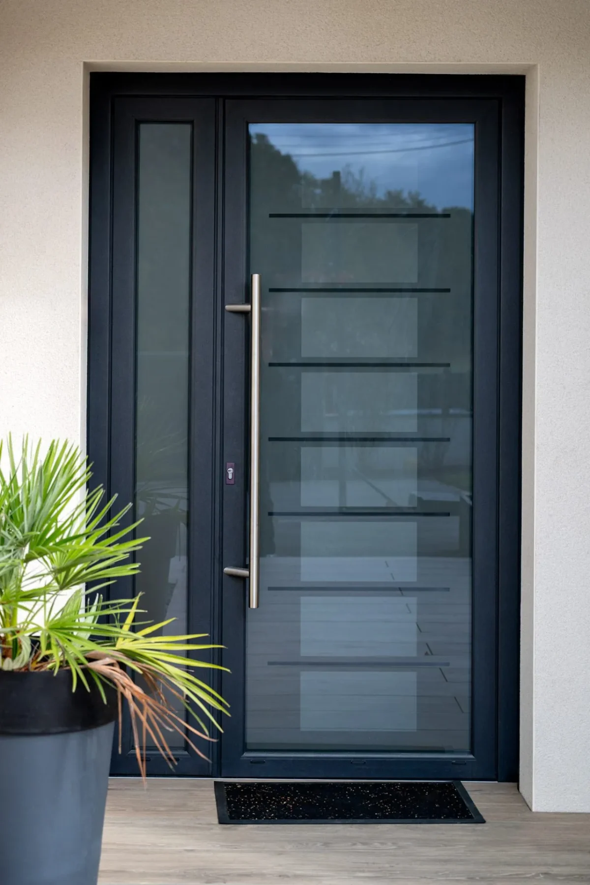Porte d'entrée vitrée en aluminium avec semi-fixe et poignée bâton, posée par Maison Aubin à Saint-Aubin-du-Cormier