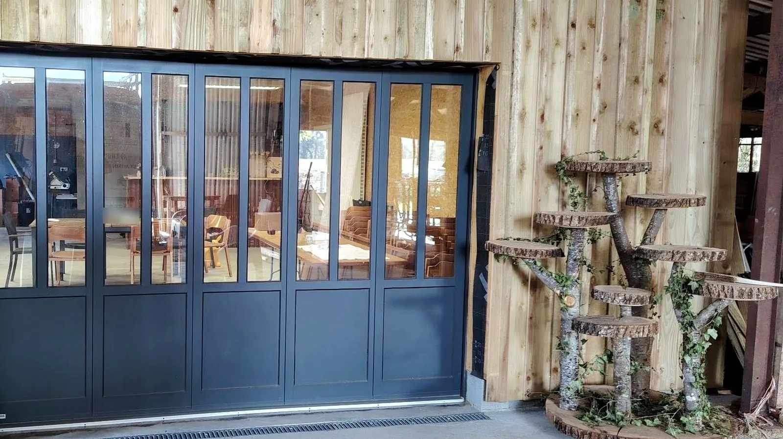 Porte de garage latérale vitrée en aluminium gris anthracite, style verrière d'atelier, fabriquée par GYPASS et posée par Maison Aubin à Balazé (35)
